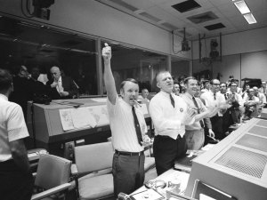 Three of the four Apollo 13 Flight Directors applaud the successful splashdown of the Command Module "Odyssey" while Dr. Robert R. Gilruth, Director, Manned Spacecraft Center (MSC), and Dr. Christopher C. Kraft Jr., MSC Deputy Director, light up cigars (upper left). The Flight Directors are from left to right: Gerald D. Griffin, Eugene F. Kranz and Glynn S. Lunney. Credit: NASA