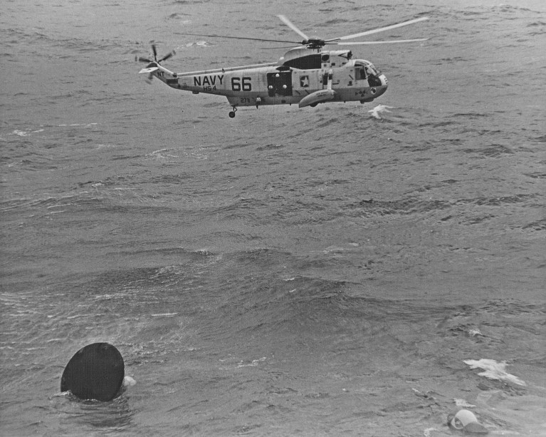 A recovery helicopter hovers over Yankee Clipper in the Stable II, seconds after splashdown