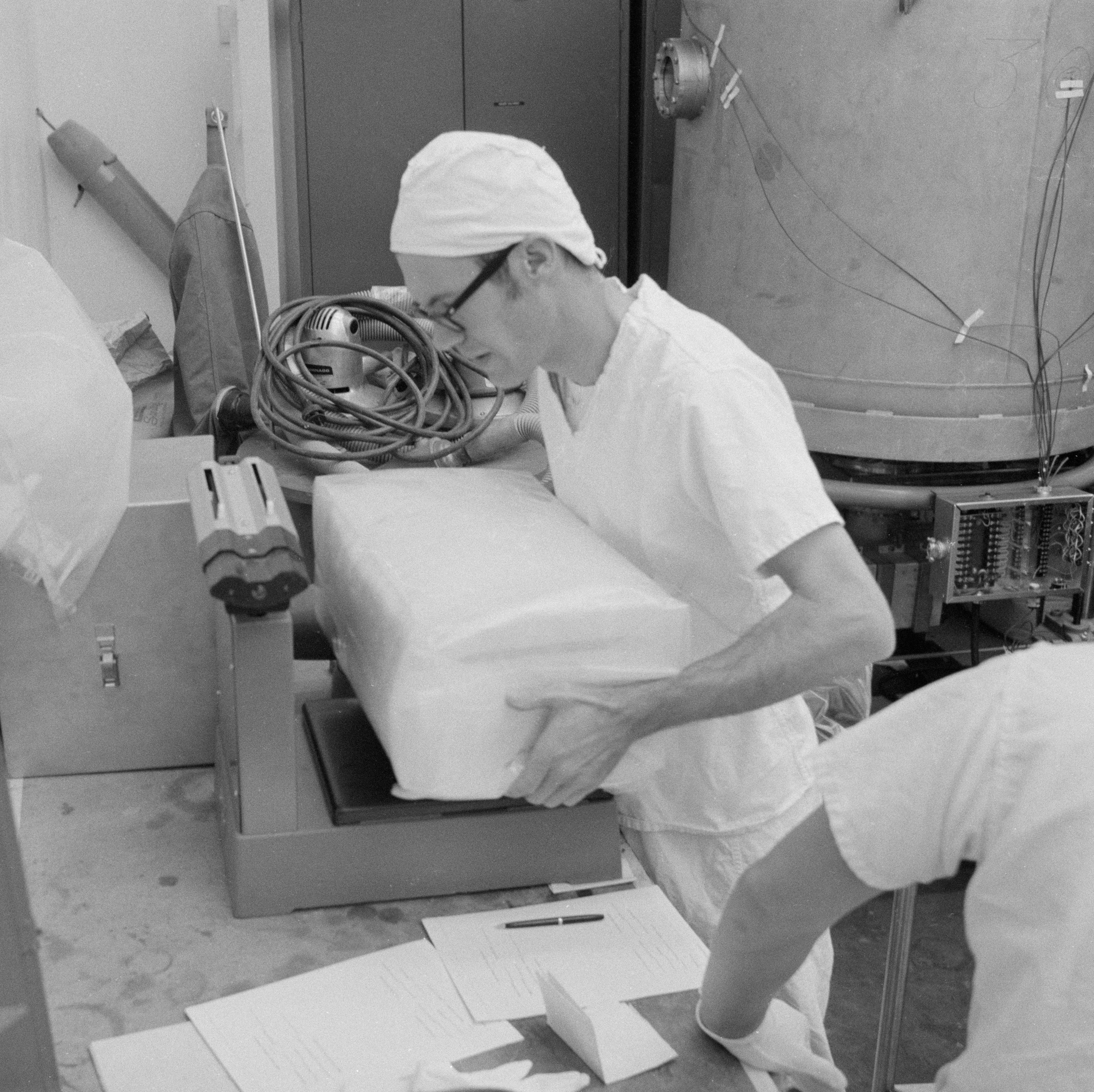 A technician weighs the first Apollo 12 Sample Return Container in the LRL