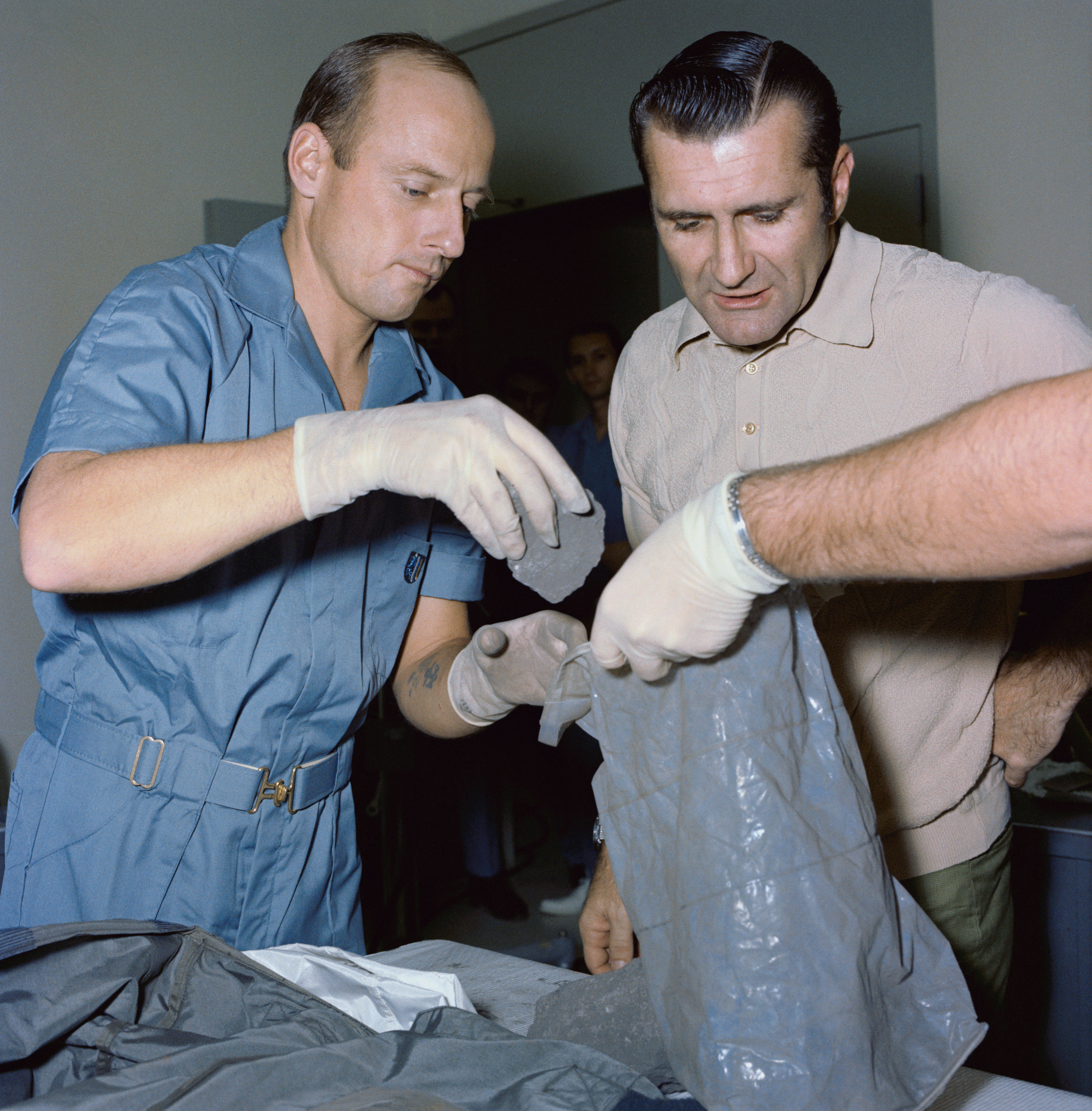 Conrad and Richard F. Gordon place the rocks samples back in the collection bags