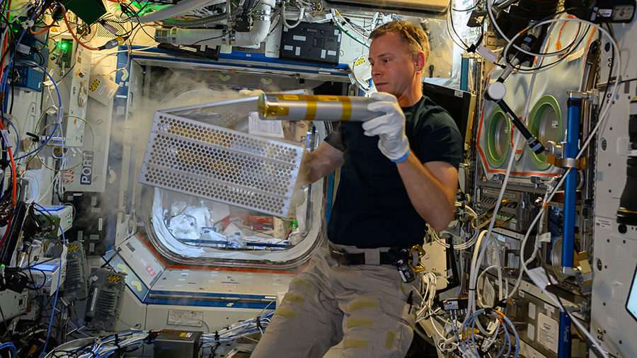 NASA astronaut Nick Hague processes samples for a biotechnology experiment that explores using microorganisms and cell cultures to produce materials and biomolecules on a commercial scale.