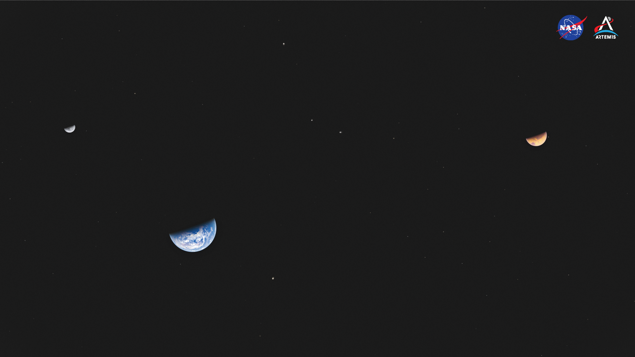 From left, an artist’s concept of the Moon, Earth, and Mars sharing the jet-black backdrop of space. At far left, a tiny Moon shrouded in shadow, the bottom half gleaming gray and bright white. Below the Moon and slightly off to the right, the bottom half of Earth is visible, showing cloud tops and an oceanic view, with the top covered in shadow. At the very far right of the virtual background, toward the upper quadrant, a partially shrouded Mars is visible. Mars is bigger than the Moon but smaller than Earth in this virtual background, its surface gleaming a rust-colored orange.