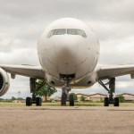 A view facing the nose of a white Boeing 777.