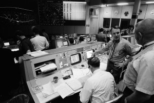 Partial view of activity in the Mission Operations Control Room in the Mission Control Center at the time the Apollo 14 S-IVB stage impacted on the lunar surface. The flight director's console is in the foreground. Eugene F. Kranz, chief of the MSC Flight Control Division, is in the right foreground. Seated at the console is Glynn S. Lunney, head of the Flight Director Office, Flight Control Division. Facing the camera is Gerald D. Griffin, flight director of the Third (Gold) Team. A seismic reading from the impact can be seen in the center background. Credit: NASA