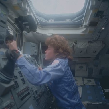 Anna L. Fisher operates the Remote Manipulator System from Discovery’s aft flight deck