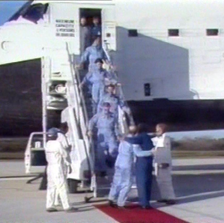 NASA officials greet the STS-51A astronauts as they exit Discovery