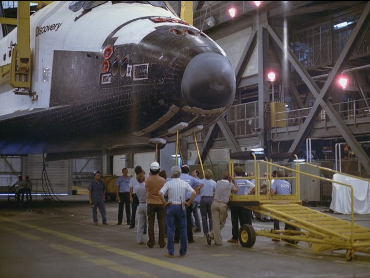 Workers in the Vehicle Assembly Building (VAB) prepare to lift Discovery for mating with an External Tank (ET) and Solid Rocket Boosters (SRBs)