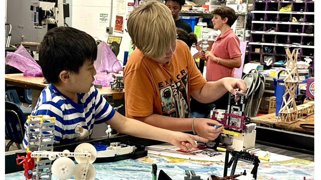 two young camp-goers building a robot