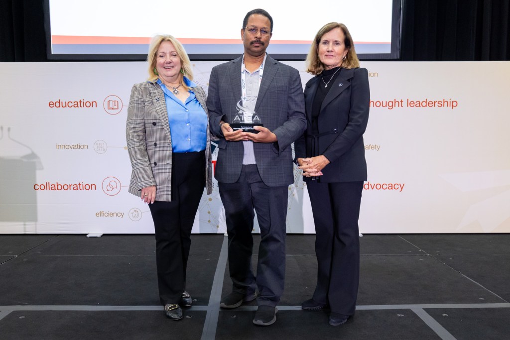 Ken Freeman (center) receives the ATCA Award for ATM-X Digital Information Platform (DIP) from Rachel Jackson, Chair ATCA Board of Directors (left) and Carey Fagan, President and CEO ATCA (right).