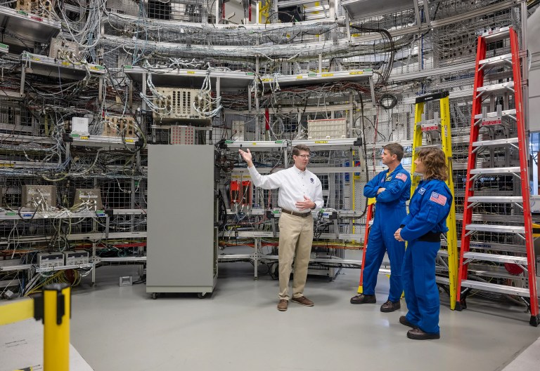 Dan Mitchell, NASA’s lead SLS integrated avionics and software engineer (left), shows Artemis II astronauts Reid Wiseman (center) and Christina Koch (right) software test facilities at NASA’s Marshall Space Flight Center in Huntsville, Alabama.