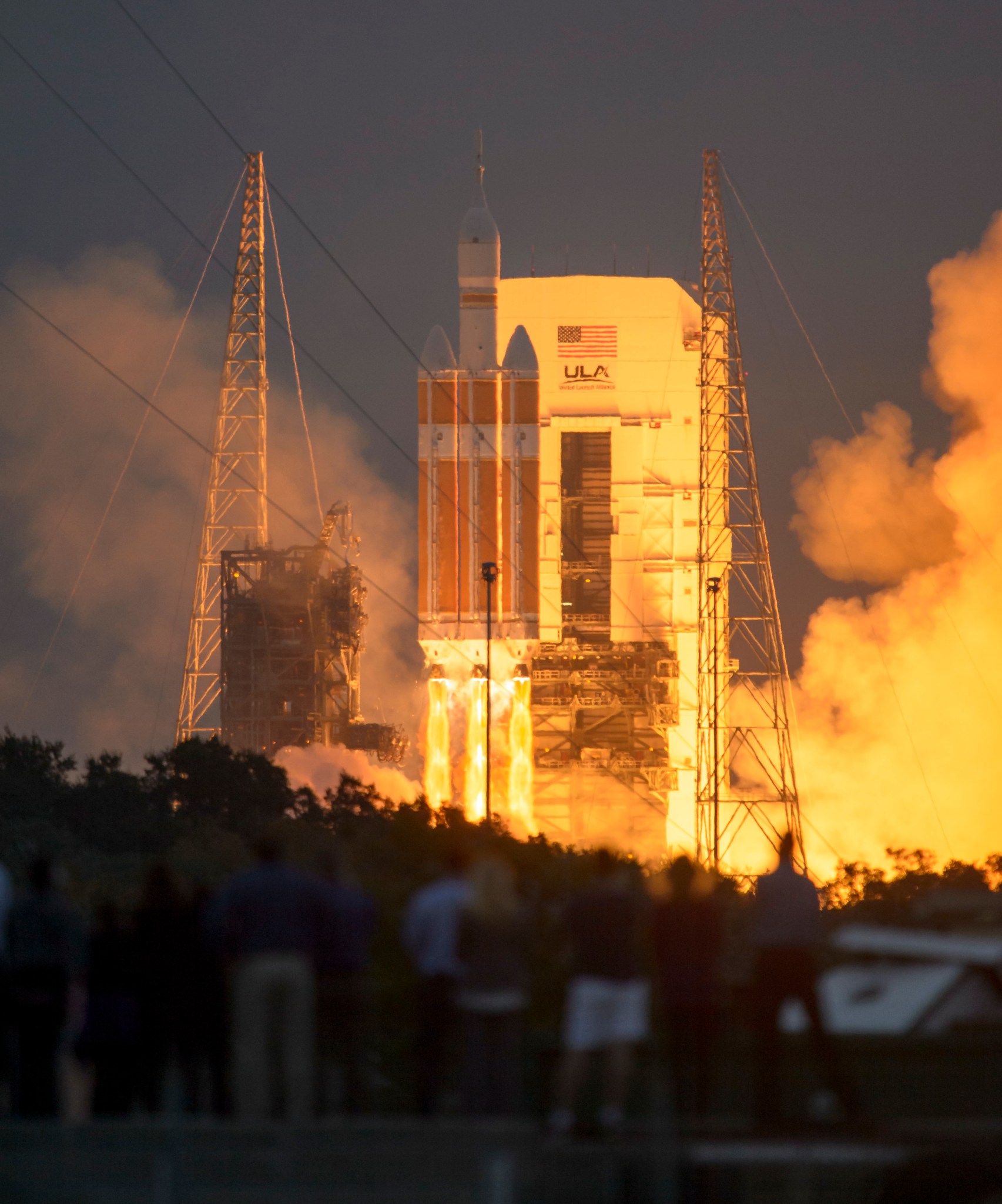 A spacecraft is launching from a launch pad. Fire and smoke billows around the rocket as it lifts into the air.