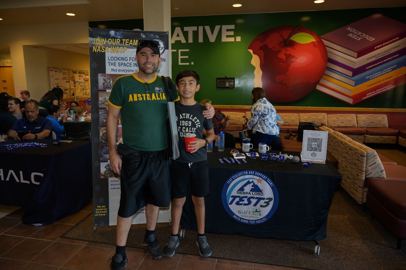 A man and his son enjoy the White Sands exhibit at the Las Cruces Space Festival.