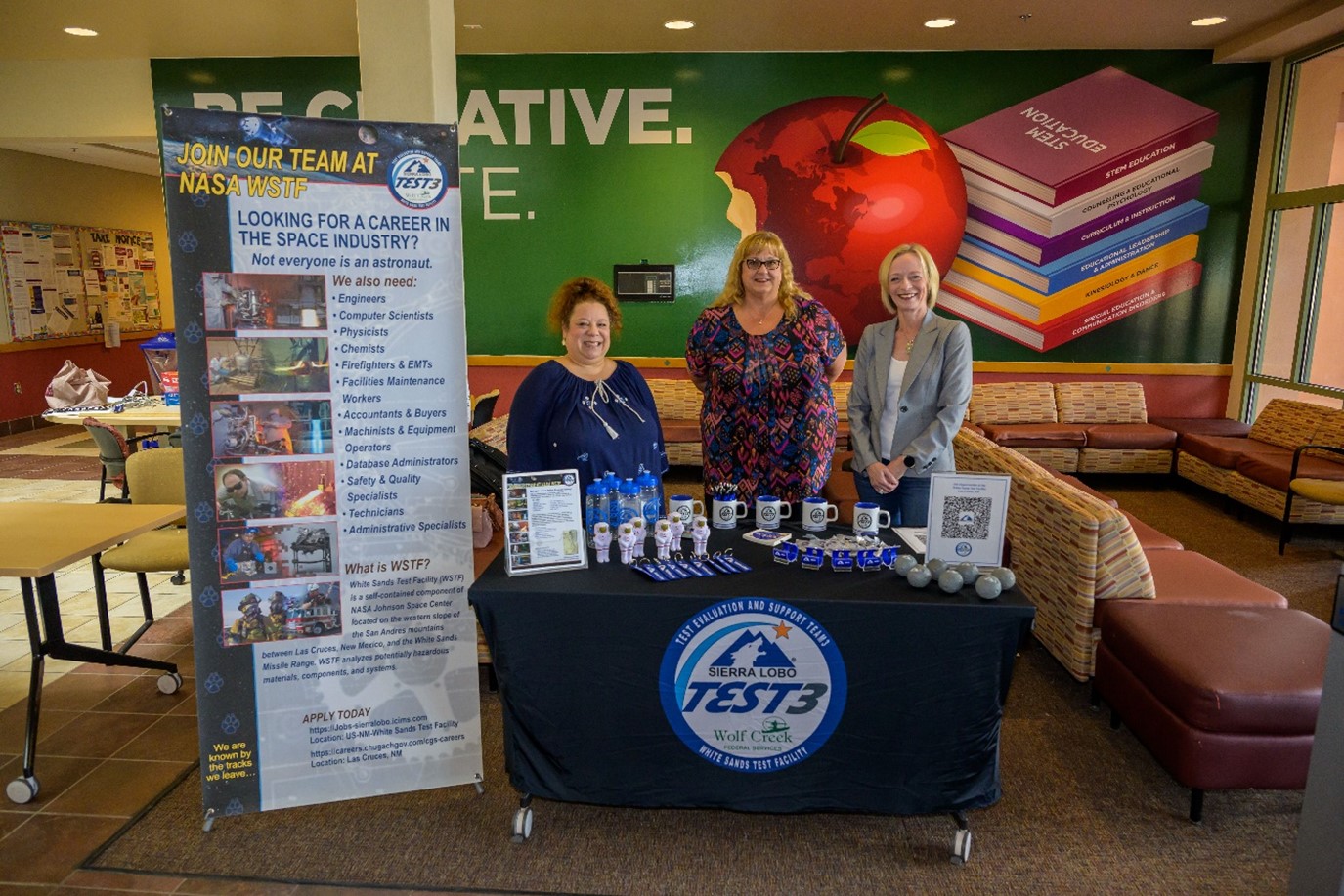 Three White Sands Test Facility team members staff a table at the Las Cruces Space Festival in New Mexico.