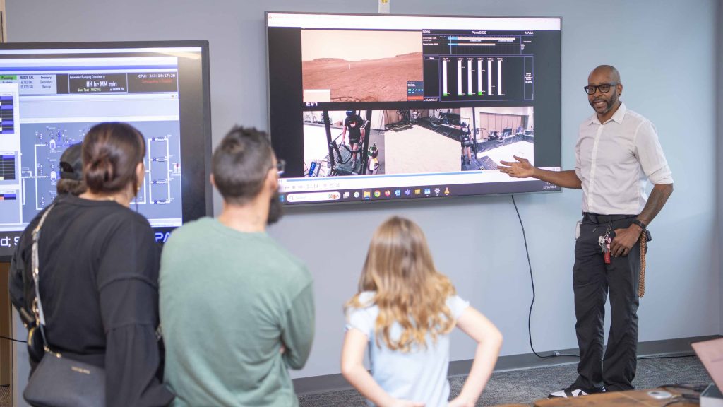 Cookbook author and culinary content creator Caroline Davis, popularly known as Mississippi Kween, and her family watch a presentation during their visit to NASA Stennis