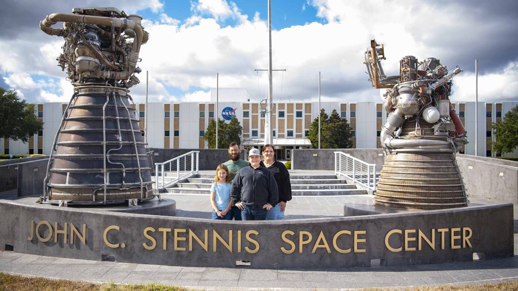 Cookbook author and culinary content creator Caroline Davis, popularly known as Mississippi Kween, and her family stand in front of the Roy Estess Building at NASA Stennis