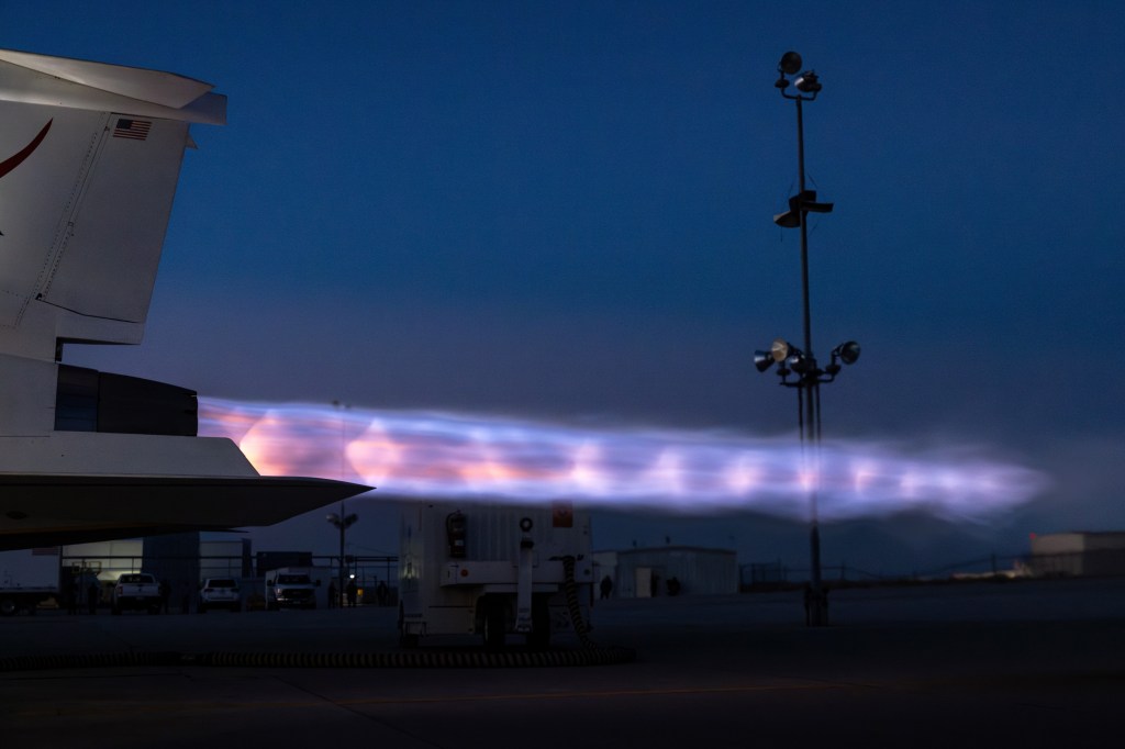 NASA’s X-59 emits bright flames with visible shock diamonds from its engine at sunset during maximum afterburner testing outside Lockheed Martin’s Skunk Works Facility in Palmdale, California.