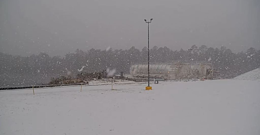 tanks at Stennis Space Center fade into background at snow continues to fall