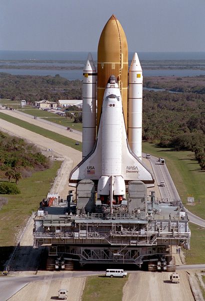 Image of a space shuttle stack rolling out to its launch pad along the crawlerway.