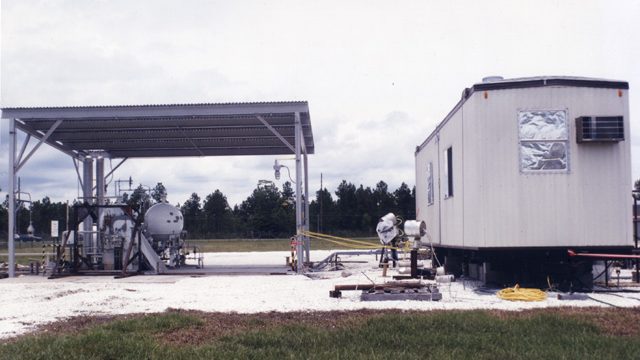 a small white mobile metal building in close proximity to the Diagnostic Testbed Facility to 