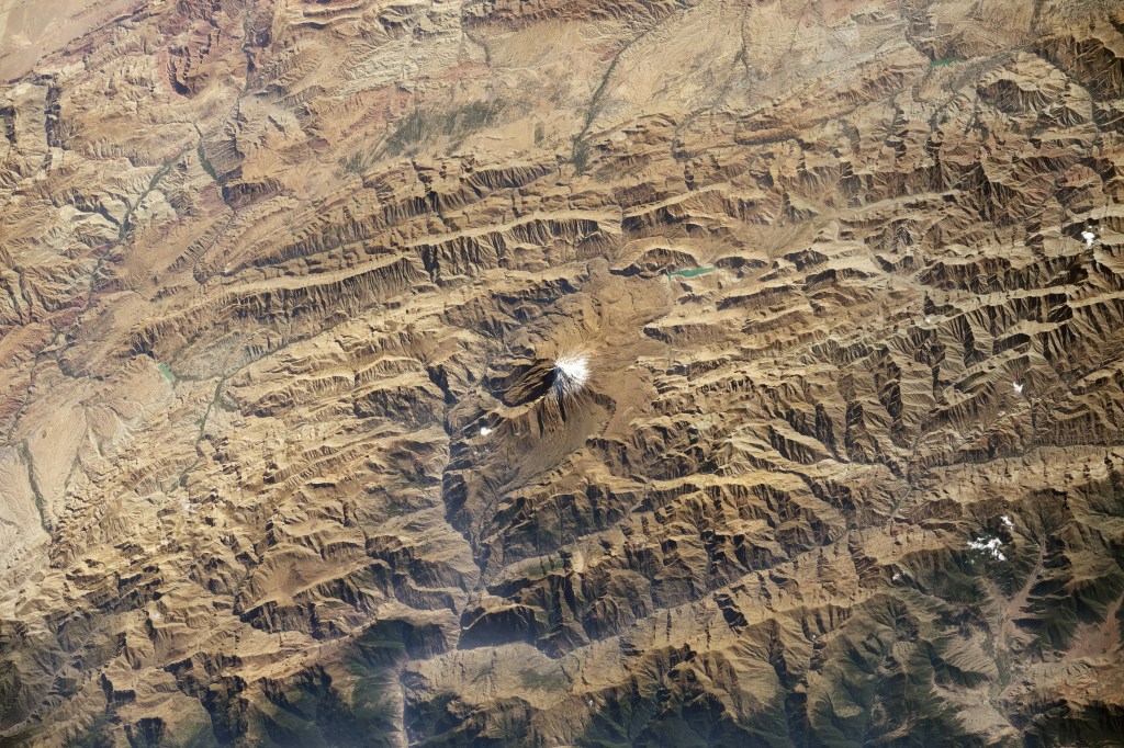 An astronaut aboard the International Space Station took this photo of Mount Damavand (also spelled Demavend) in the Alborz Mountains of northern Iran. Damavand is a dormant volcano with a cone much larger than the white snow-clad summit pictured here in early autumn 2024.