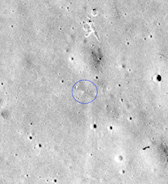 Black and white image of a portion of the Moon with a blue circle indicating Ranger 8's impact point.