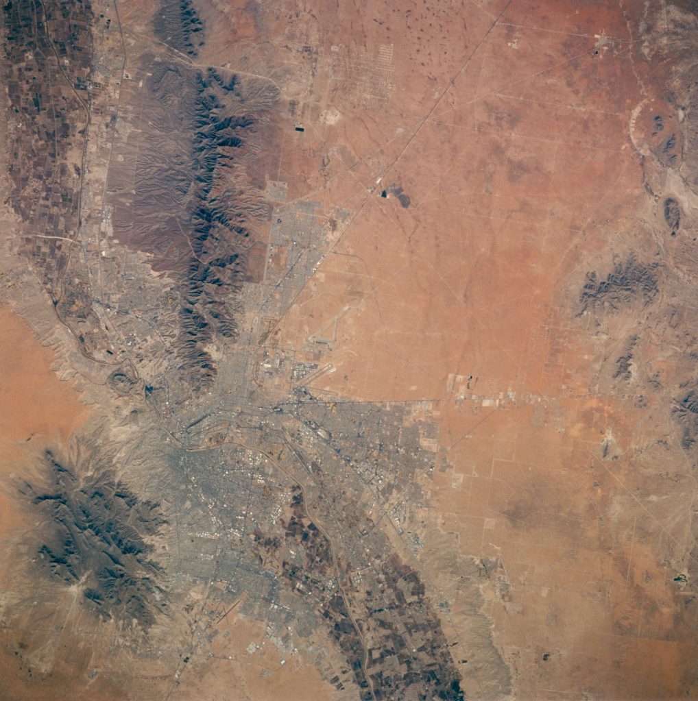 Orbital view of El Paso, Texas, showing mostly a reddish desert landscape.