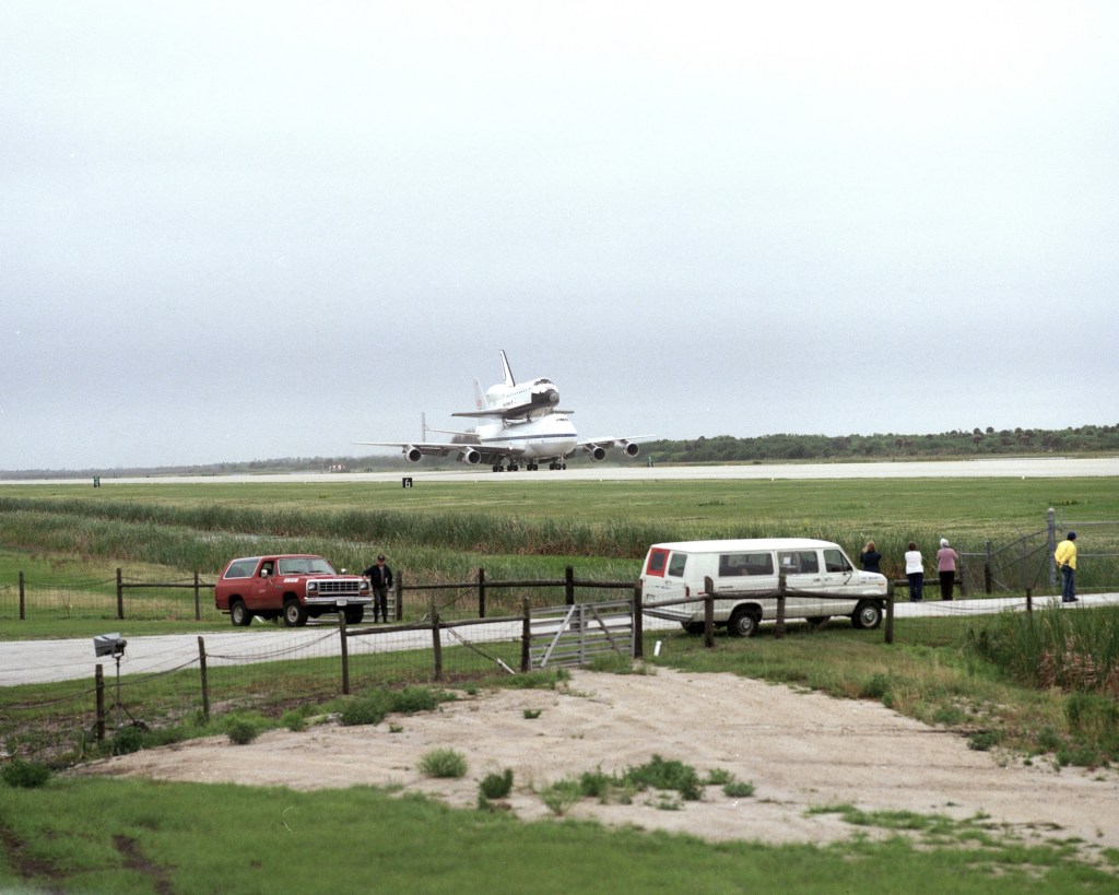 View of a space shuttle atop its shuttle carrier aircraft making a landing.