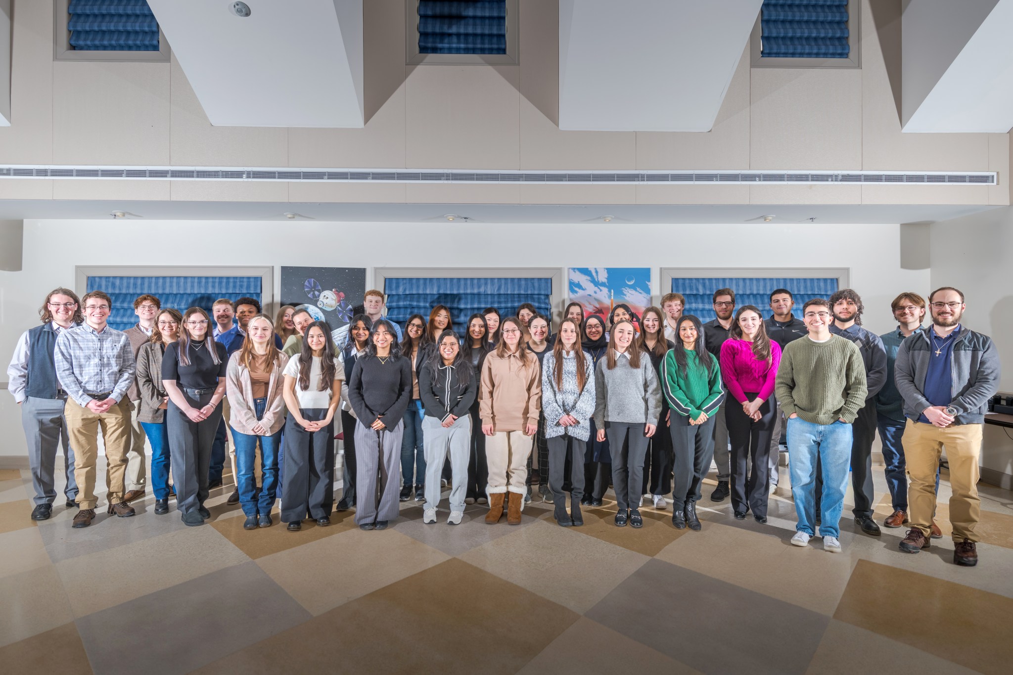 A large group of smiling college-age students gather for a group photo.