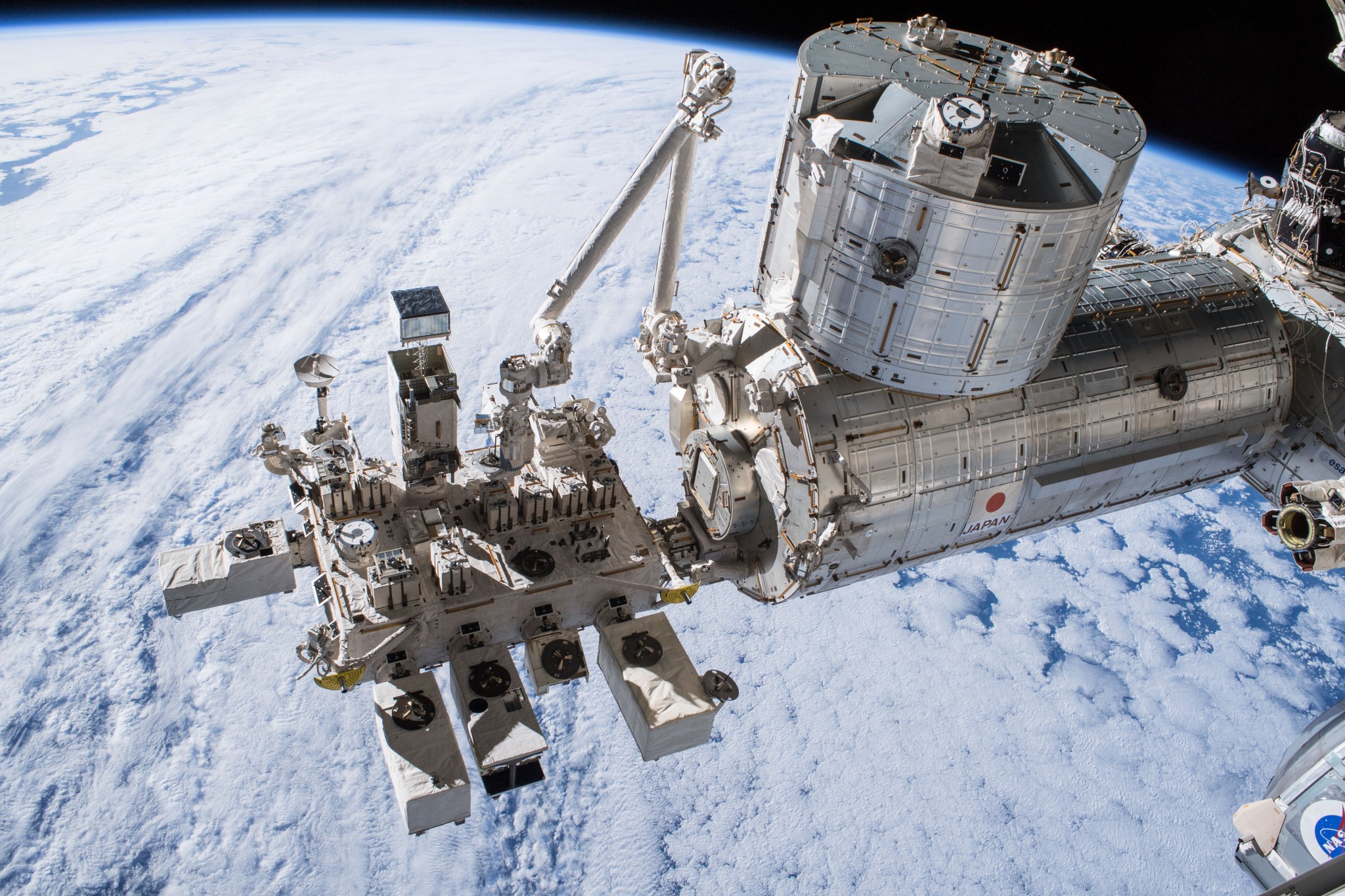 An image of a telescope on the International Space Station with a view of Earth in the background.