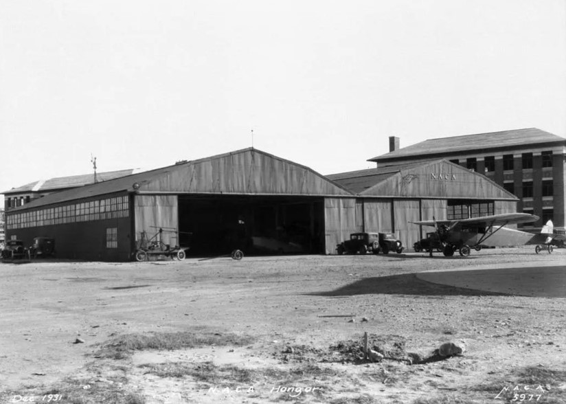 Black and white image of two wooden airplane hangars.