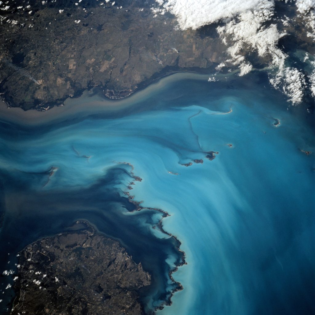 View from space of a gulf with blue waters and brown land on both sides.