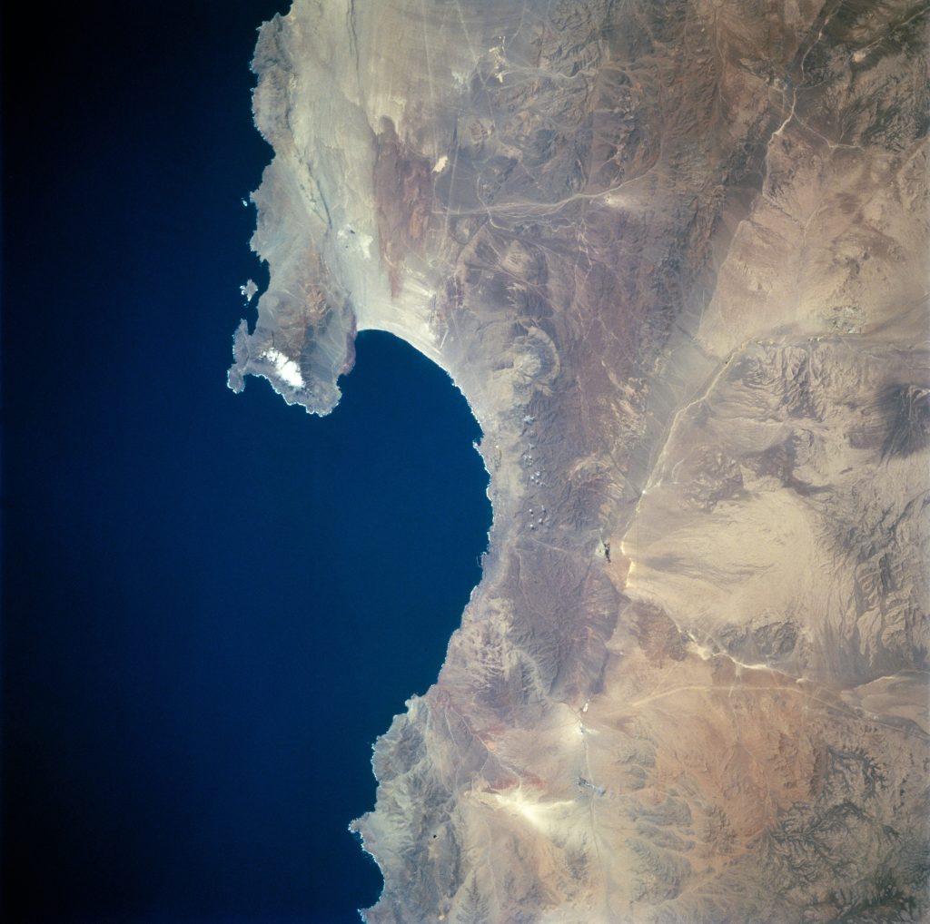 View from space of a desert coastline on the right and ocean on the left.