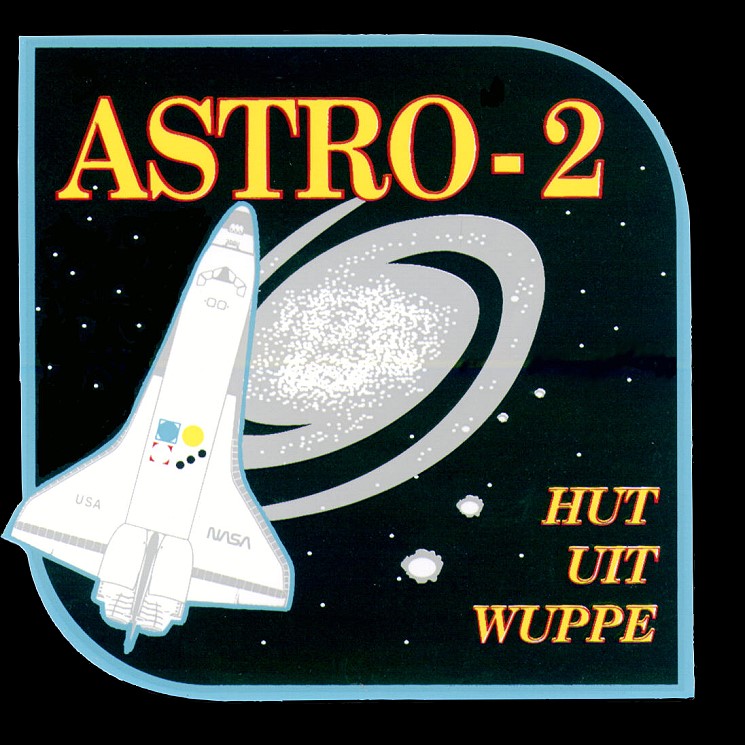 Square patch with a space shuttle and a stylized spiral galaxy and the word ASTRO-2 printed in yellow capitals.