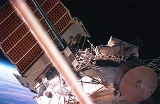 Yury Usachev (blue stripe on EMU) works to install the truss on the module.