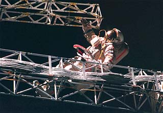 Onufriyenko stands on the Sofora truss, with one hand on the Rapana truss next to it. 