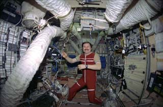 Mir-25 crewmember Nikolai Budarin works in the Mir Space Station Base Block. 