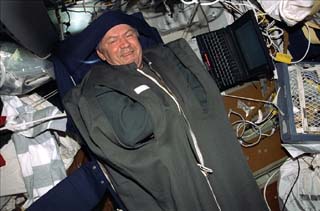 Mission Specialist Valery Ryumin demonstrates the sleep restraint he used in the middeck.